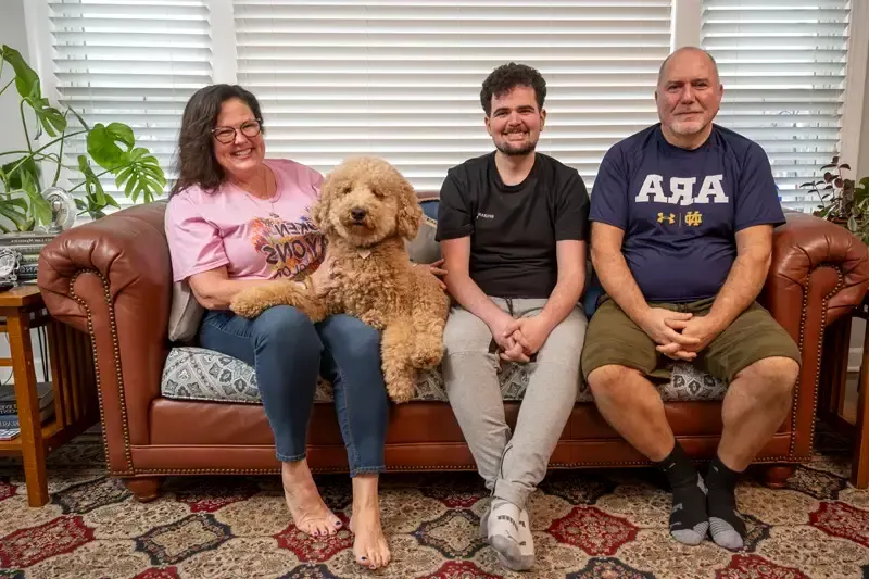 From left to right, Harry, Alec, Lucy (dog), and Gail Koujaian at home.